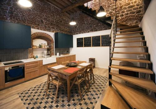 een keuken met een houten tafel en een trap bij Casa Betta - A 700 Year Old Tuscan Gem in Chiusdino