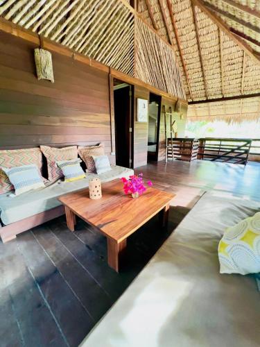 a room with a wooden table and a bed at Casa do Boi, charming house ideally located in Atins ! in Atins