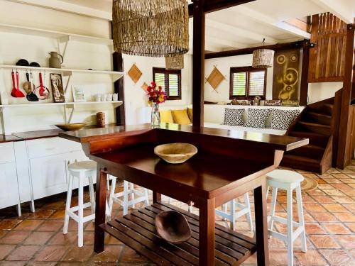 a kitchen with a wooden table and stools at Casa do Boi, charming house ideally located in Atins ! in Atins
