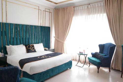 a hotel room with a bed and a blue chair at Envoy Express, Islamabad in Islamabad