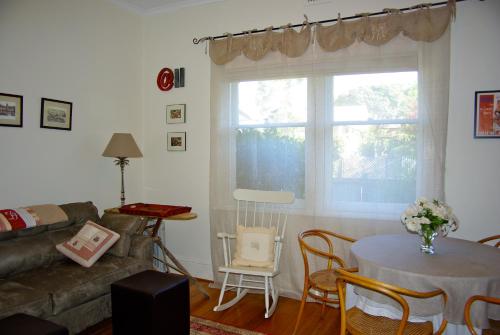 a living room with a couch and a table and a window at At Eleven - La Petite Maison in Sandy Bay
