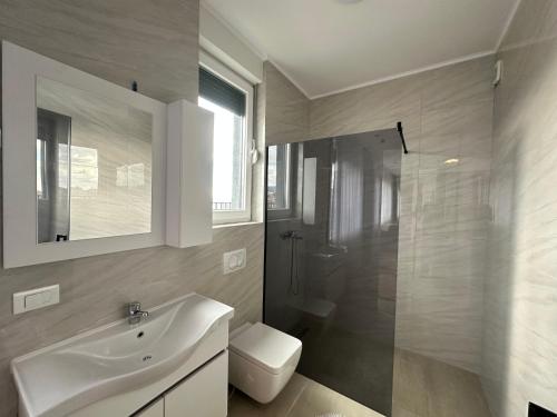 Un baño con lavabo, ducha e inodoro. en Pri-Penthouse - CityView, en Pristina
