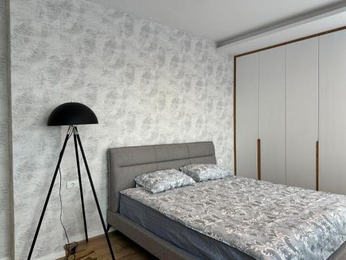 Un dormitorio con una cama y una lámpara negra. en Pri-Penthouse - CityView, en Pristina