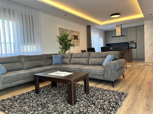 Una sala de estar con un sofá y una mesa de café. en Pri-Penthouse - CityView, en Pristina