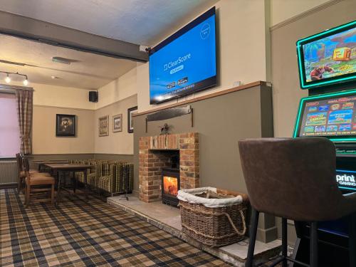 a game room with a fireplace and a flat screen tv at The vale of york in Thirsk