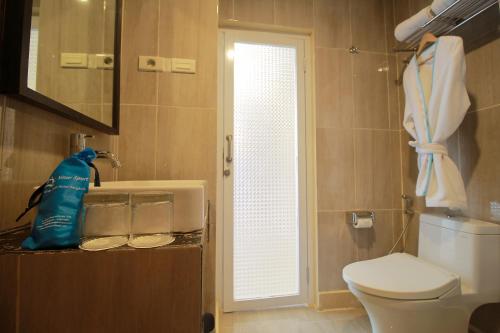 łazienka z toaletą, umywalką i oknem w obiekcie Sinar Sport Hotel w mieście Bengkulu