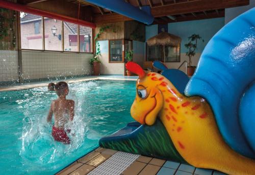 Młoda dziewczyna jest w basenie. w obiekcie Vakantiepark Sallandshoeve w mieście Nieuw-Heeten