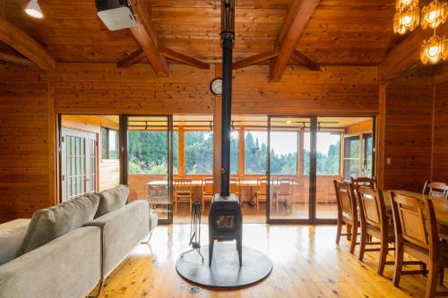 a living room with a woodburning stove in a house at Echoes of Forest エコーズオブフォレスト 森の音が聴こえるロッジ in Minamioguni