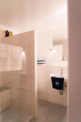 a white bathroom with a sink and a mirror at Ferienwohnung in der Kirchgasse in Landshut