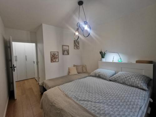 アウグストゥフにあるApartament pod modrzewiemのベッドルーム1室(大型ベッド1台、照明2つ付)