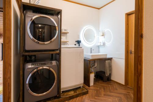a washer and dryer in a bathroom with a mirror at Echoes of Forest エコーズオブフォレスト 森の音が聴こえるロッジ in Minamioguni