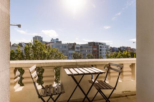 two chairs and a table on a balcony at Huswell - New Penthouse with City & Harbour Views in Ostend