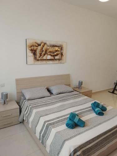 a bedroom with a bed with two blue towels on it at Sorrento in St. Julianʼs