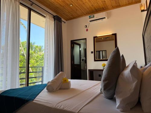 a bedroom with a bed with a large window at Clear Point Studio in Dickwella