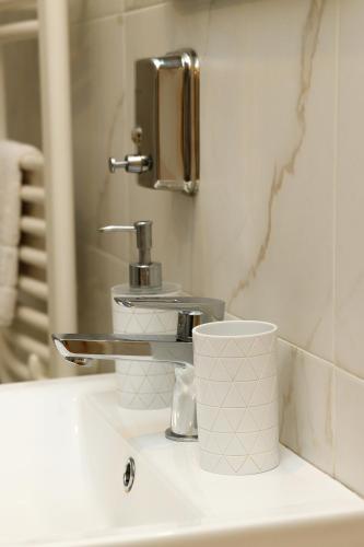 a bathroom sink with a faucet and a mirror at Перлина Лумшор in Lumshory