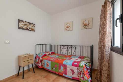 ein kleines Schlafzimmer mit einem Bett und einem Nachttisch in der Unterkunft La Casita Villalba in Arrieta