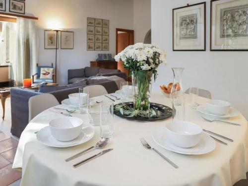 a table with white dishes and a vase of flowers at Apartment Chesa Prasüra 10 by Interhome in Sils Maria