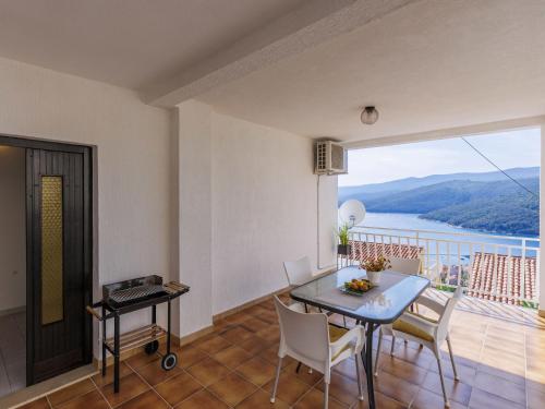 a living room with a table and chairs and a balcony at Apartment Katarina-1 by Interhome in Rabac