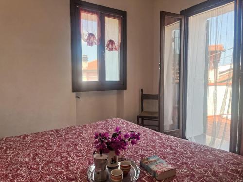 Una mesa con flores moradas en jarrones sobre una mesa. en Apartment Marisa - DOL126 by Interhome, en Costa Carnara