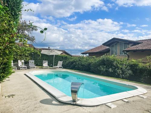 a swimming pool with a chair next to a house at Holiday Home Villa Felice by Interhome in Asti