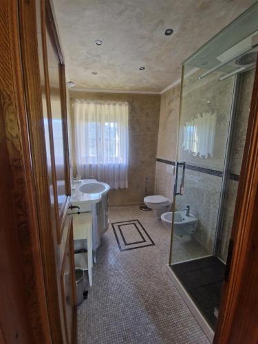 a bathroom with two sinks and a toilet and a shower at Mammolino - Medieval Mini-villa with Jacuzzi and stunning views in Lucca