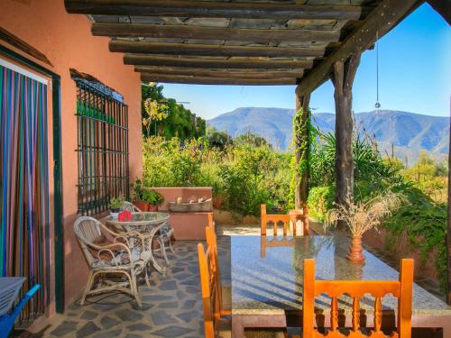 a patio with a table and chairs and a view of mountains at Holiday Home El Cerrillo - Cerro Negro by Interhome in Órgiva