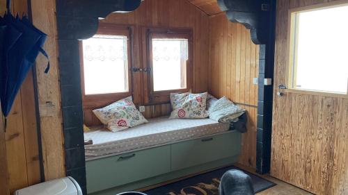 a small bench in a room with two windows at Chalet La Marmotte 1800m in Ollon