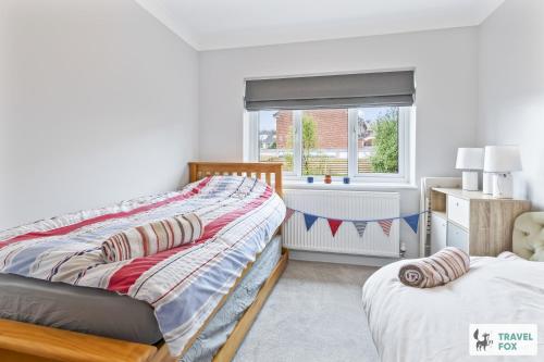 Un dormitorio con dos camas y una ventana. en Coastal Breeze Retreat, en Swanage