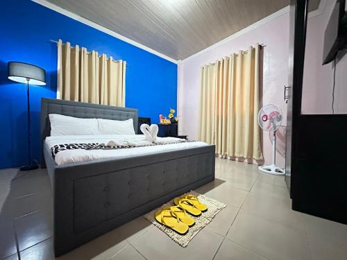 a bedroom with a bed with yellow shoes on the floor at Sukhavati Inn in Baguio