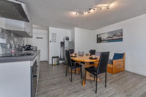eine Küche und ein Esszimmer mit Tisch und Stühlen in der Unterkunft Les Anémones 6 places in Les Orres