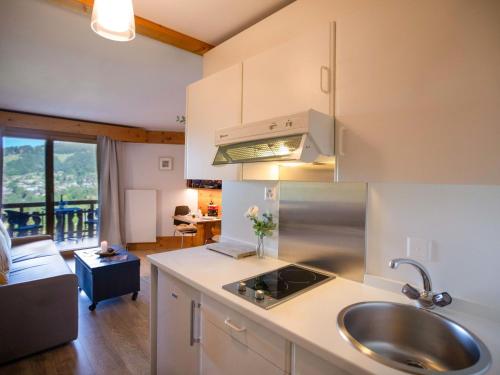 eine Küche mit Spüle und ein Wohnzimmer in der Unterkunft Studio Le Bristol A25-31 by Interhome in Villars-sur-Ollon
