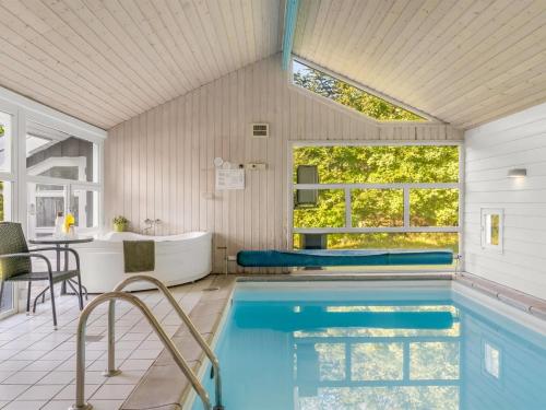 a swimming pool in a house with a tub and a sink at Holiday Home Mechthild - 2-7km from the sea by Interhome in Saltum