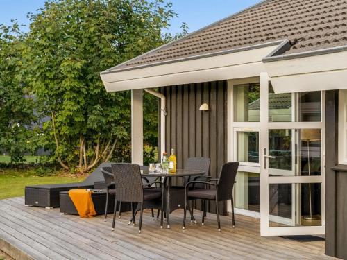 a patio with a table and chairs on a deck at Holiday Home Mechthild - 2-7km from the sea by Interhome in Saltum