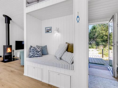 a white living room with a couch in the wall at Holiday Home Aarthi - 575m from the sea by Interhome in Læsø