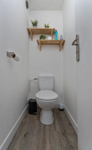a bathroom with a white toilet and a wooden floor at Les Anémones 6 places in Les Orres