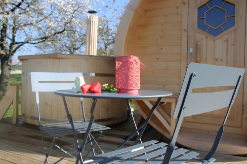 a table and two chairs in front of a cabin at Barrel Papilles En Escapade in LʼÉpaux
