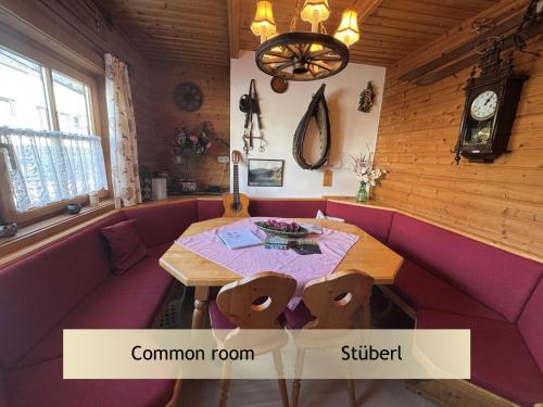 een eetkamer met een tafel en een paarse bank bij Gerhards Landhaus in Wagrain