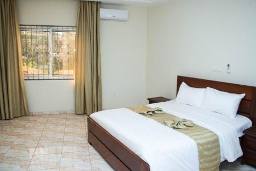 a bedroom with a large bed and a window at Yaoundé in Yaoundé