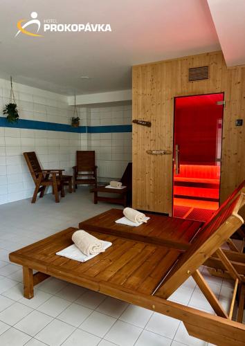 a room with two wooden beds and a red bench at Hotel Prokopávka in Pilsen