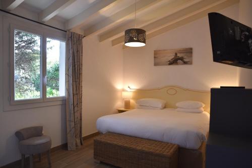 une chambre avec un lit et une fenêtre dans l'établissement Santa Giulia - Le village de L'hacienda, à Porto-Vecchio