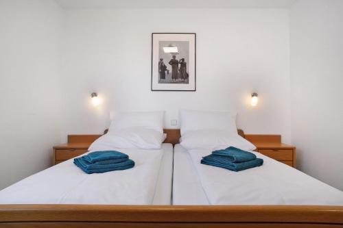 a bedroom with two beds with blue towels on them at Gästehaus Heinemann - Og1 in Langenargen