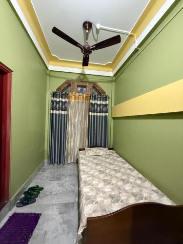 a bed in a room with a ceiling fan at The Family Haven Homestay in Golāghāt