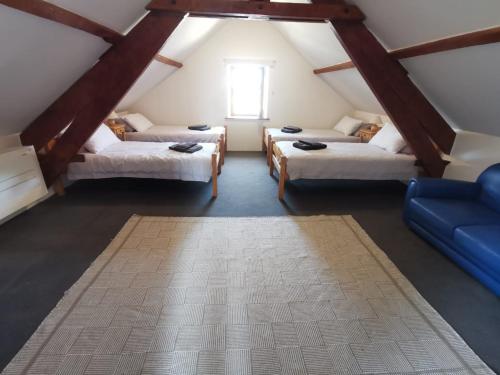 a attic room with three beds and a blue couch at Charming Countryside Retreat in Saint-Georges in Clavé