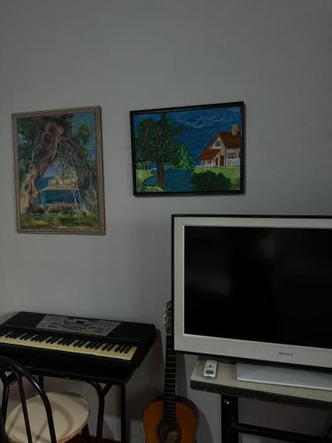 a room with a keyboard and a tv and a monitor at Bliss Inn Hostel & Tours in Shkodër