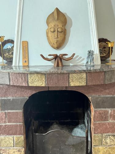 a mask sitting on top of a brick fireplace at Bliss Inn Hostel & Tours in Shkodër