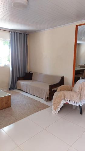 a bedroom with a bed and a chair in it at Apartamento Tucano in Alto Paraíso de Goiás