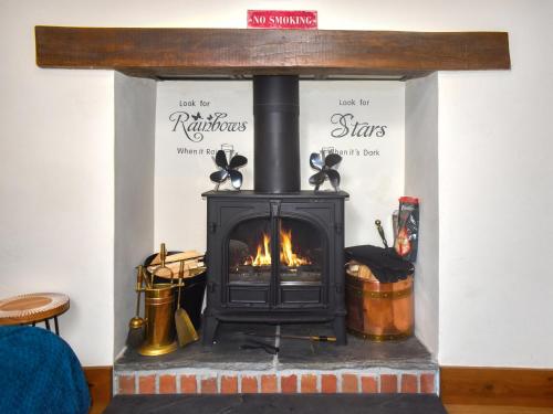 a fireplace with a stove in a room at Mariners Cottage in Dawlish