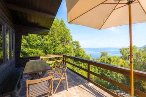 a table and chairs on a balcony with an umbrella at Casette nel Parco in Portoferraio