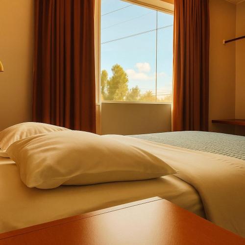 sypialnia z łóżkiem i dużym oknem w obiekcie Hotel Silver w mieście Tacna