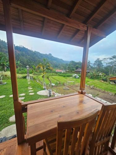 a view of a garden from a porch with a wooden table at Arta Dani villas in Sidemen